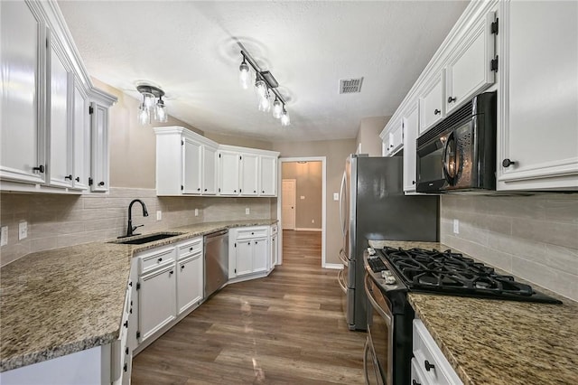 kitchen with white cabinets, sink, dark hardwood / wood-style floors, light stone counters, and stainless steel appliances