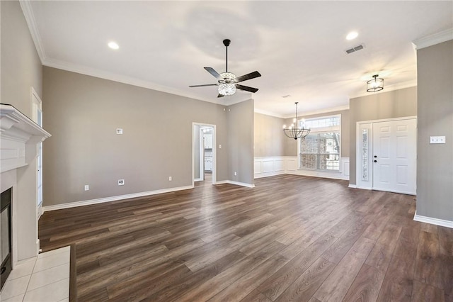 unfurnished living room featuring ceiling fan with notable chandelier, wood-type flooring, and crown molding