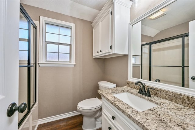 full bathroom with hardwood / wood-style floors, vanity, shower / bath combination with glass door, lofted ceiling, and toilet