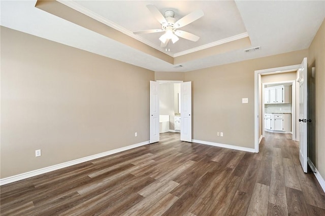 unfurnished bedroom featuring dark hardwood / wood-style flooring, a raised ceiling, ceiling fan, and ornamental molding