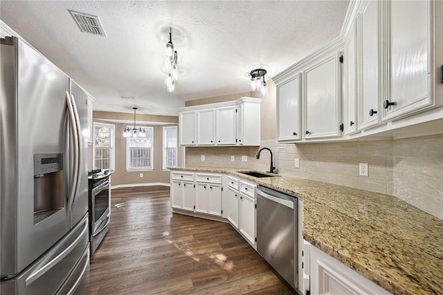 kitchen with sink, dark hardwood / wood-style flooring, light stone counters, white cabinetry, and stainless steel appliances