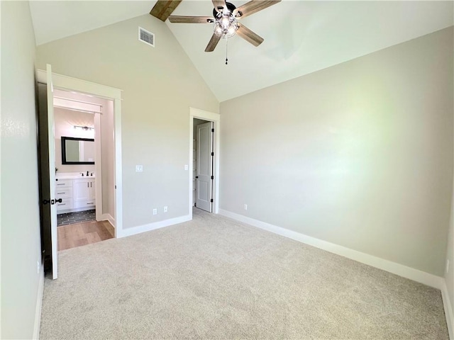 unfurnished bedroom with connected bathroom, ceiling fan, beamed ceiling, high vaulted ceiling, and carpet floors