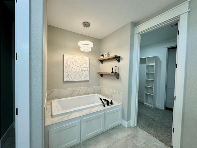 bathroom featuring a bathtub and a notable chandelier