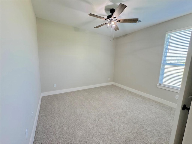 carpeted spare room featuring ceiling fan