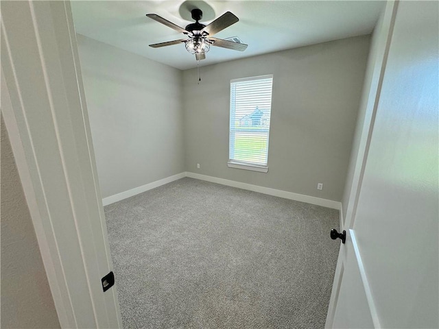 carpeted spare room featuring ceiling fan