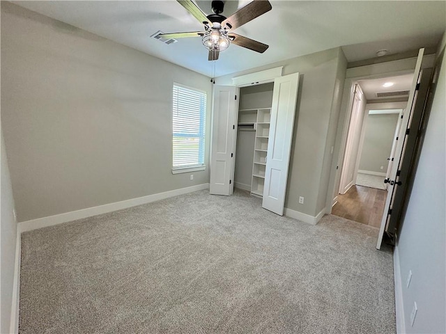 unfurnished bedroom featuring ceiling fan, light colored carpet, and a closet