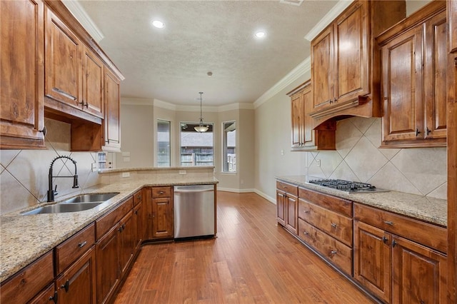 15613 Wood Brook Ln, College Station, TX 77845 - kitchen with appliances with stainless steel finishes, wood finished floors, a peninsula, a textured ceiling, and light stone counters