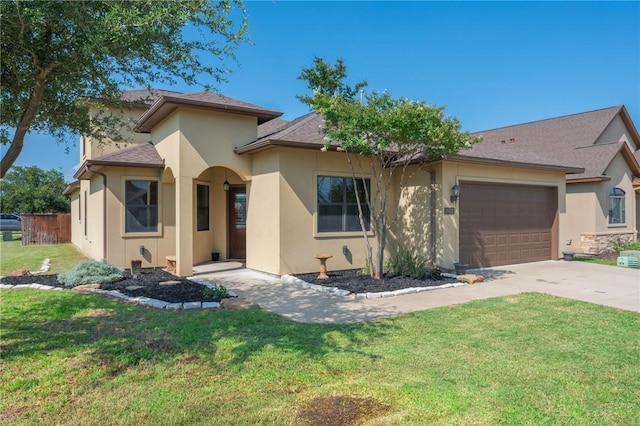 15613 Wood Brook Ln, College Station, TX 77845 - view of front facade with stucco siding, an attached garage, driveway, and a front lawn