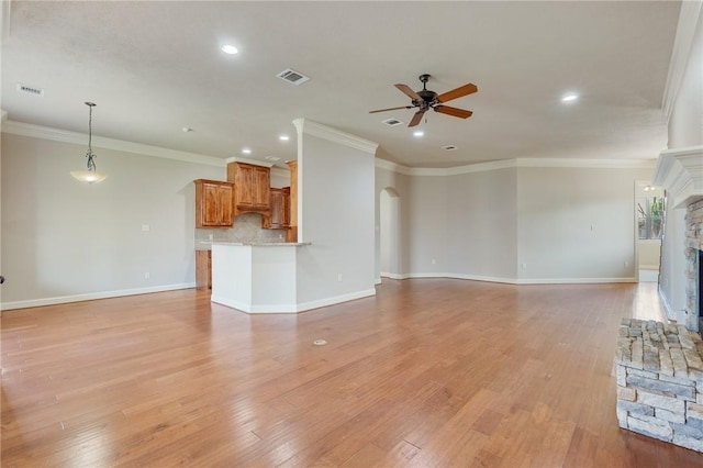 15613 Wood Brook Ln, College Station, TX 77845 - unfurnished living room featuring a ceiling fan, arched walkways, recessed lighting, a stone fireplace, and light wood finished floors