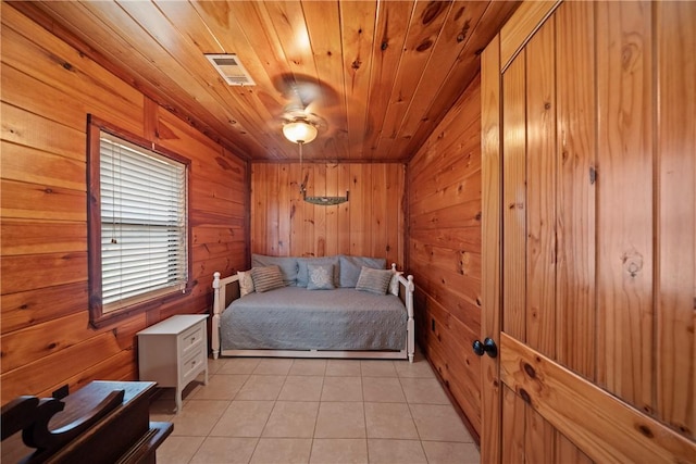 unfurnished bedroom with wooden ceiling, light tile patterned floors, visible vents, and wood walls