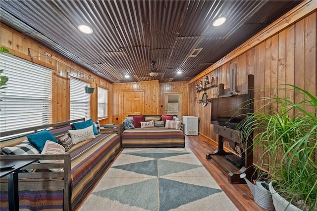 living room featuring recessed lighting, visible vents, wooden walls, and wood finished floors