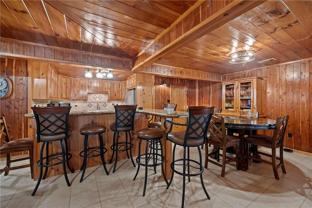 kitchen featuring tasteful backsplash, freestanding refrigerator, a peninsula, wood walls, and wood ceiling