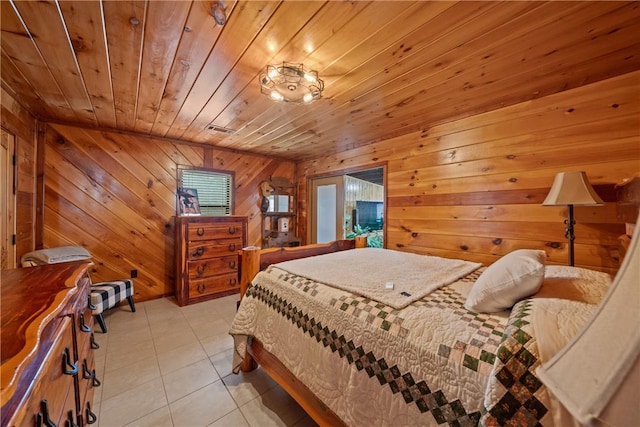 bedroom with light tile patterned flooring, visible vents, wood walls, and wood ceiling