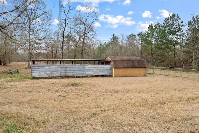 view of yard featuring an outdoor structure and fence