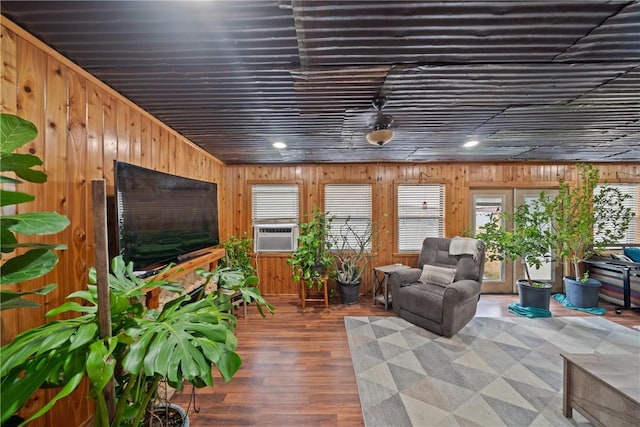 living area with wooden walls, cooling unit, and wood finished floors