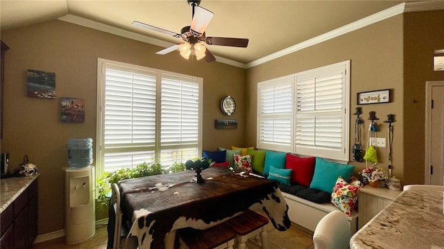 tiled dining room featuring ceiling fan, crown molding, and vaulted ceiling