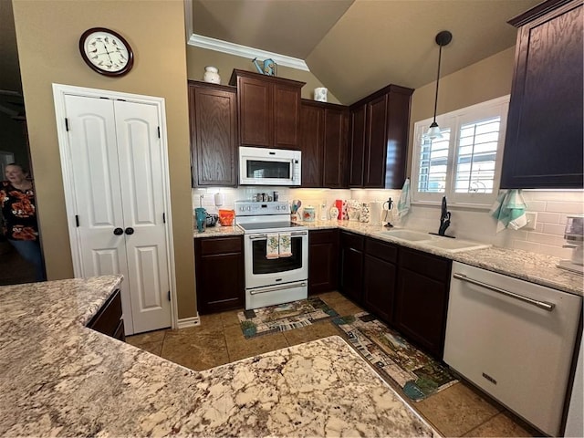 kitchen with pendant lighting, white appliances, sink, and tasteful backsplash