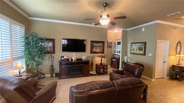 living room featuring ceiling fan, crown molding, light tile patterned floors, and a healthy amount of sunlight