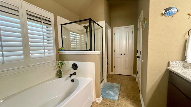 bathroom featuring tile patterned flooring, vanity, and plus walk in shower