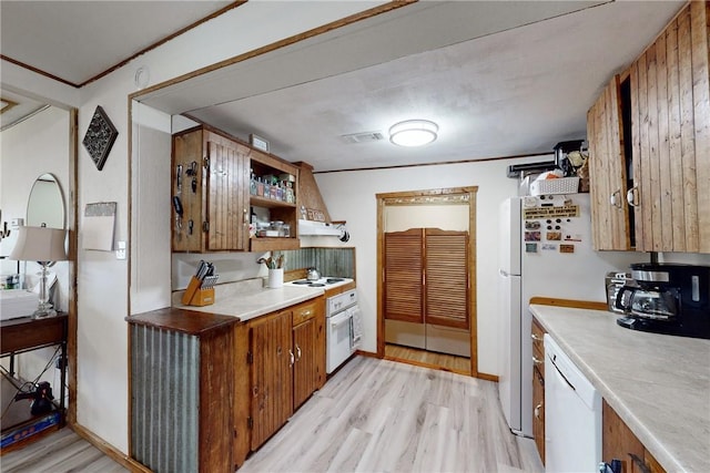 kitchen featuring white appliances, crown molding, and light hardwood / wood-style flooring