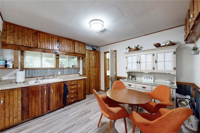 kitchen featuring a textured ceiling, light wood-type flooring, and sink