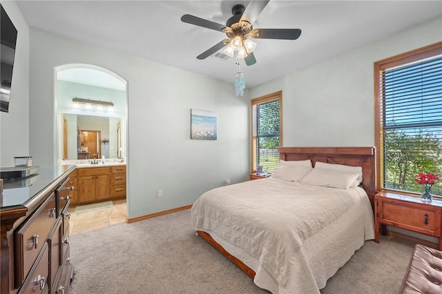 carpeted bedroom featuring ceiling fan, ensuite bath, and sink