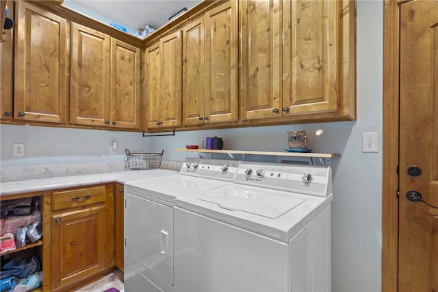 washroom with cabinets and washing machine and clothes dryer