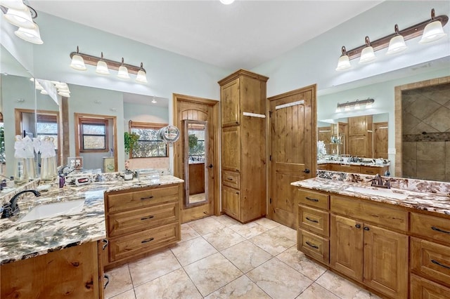 bathroom featuring vanity, tile patterned flooring, and a shower