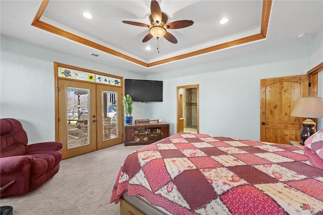 bedroom with ceiling fan, light colored carpet, french doors, and a tray ceiling