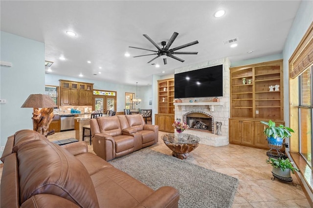 living room featuring a fireplace, built in features, ceiling fan, and light tile patterned floors