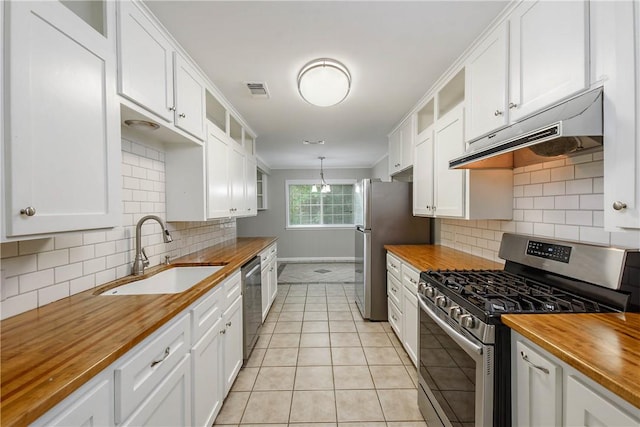 806 Matous Dr, Bryan, TX 77802 - kitchen featuring wooden counters, stainless steel appliances, a sink, under cabinet range hood, and baseboards