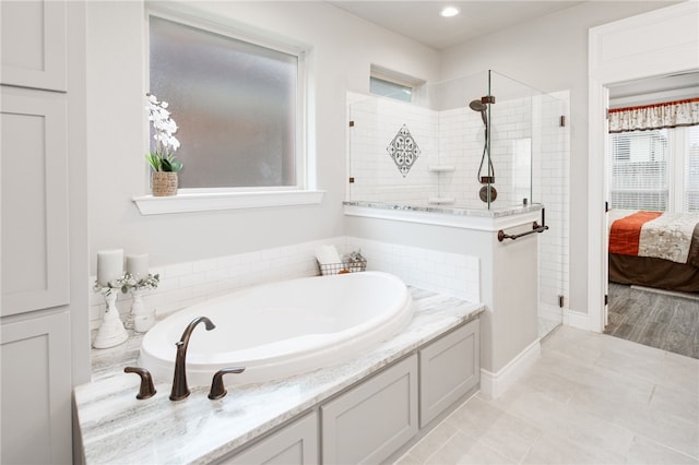 bathroom featuring tile patterned flooring and shower with separate bathtub