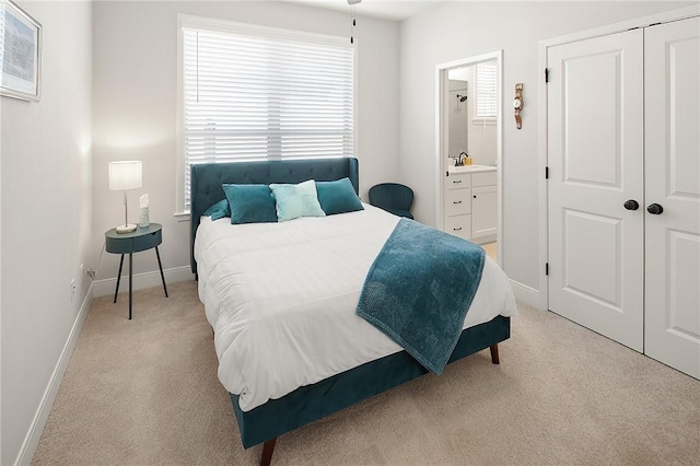 3609 Llano River Dr, College Station, TX 77845 - bedroom with light carpet, baseboards, connected bathroom, a sink, and a closet