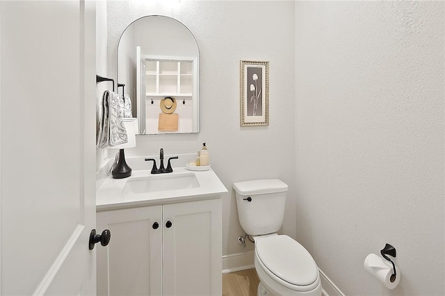 3609 Llano River Dr, College Station, TX 77845 - half bathroom featuring vanity, toilet, baseboards, and wood finished floors