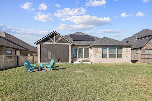 3609 Llano River Dr, College Station, TX 77845 - back of house featuring roof mounted solar panels, brick siding, a shingled roof, and a sunroom