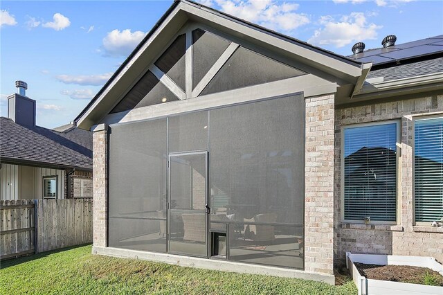3609 Llano River Dr, College Station, TX 77845 - rear view of house featuring a sunroom, solar panels, and brick siding
