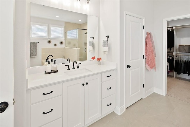 3609 Llano River Dr, College Station, TX 77845 - full bath featuring a shower stall, a walk in closet, vanity, tile patterned floors, and baseboards