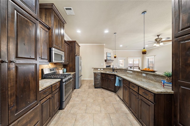 kitchen featuring appliances with stainless steel finishes, ceiling fan, pendant lighting, light stone counters, and dark brown cabinets