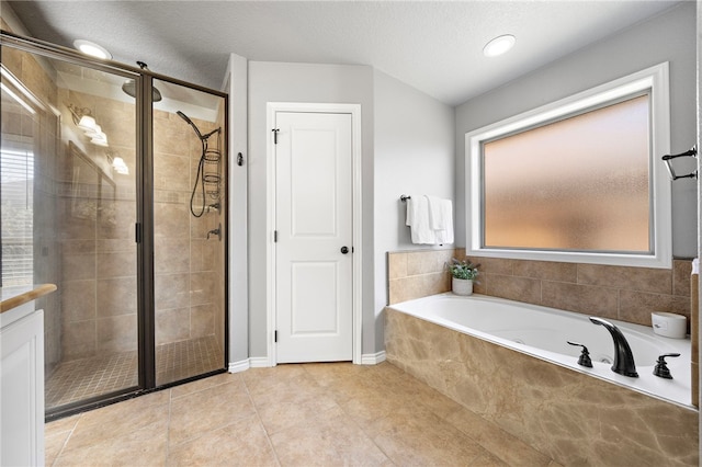 bathroom featuring a healthy amount of sunlight, a textured ceiling, tile patterned floors, and shower with separate bathtub