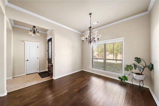 unfurnished dining area with hardwood / wood-style flooring, an inviting chandelier, and ornamental molding