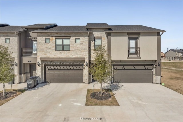 547 Hayes Ln, College Station, TX 77845 - view of front of house featuring a balcony, an attached garage, concrete driveway, and stone siding