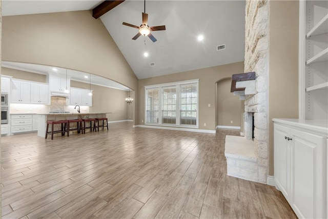 3520 Foxcroft Path, Bryan, TX 77808 - living area featuring beamed ceiling, high vaulted ceiling, ceiling fan, light wood-type flooring, and a fireplace