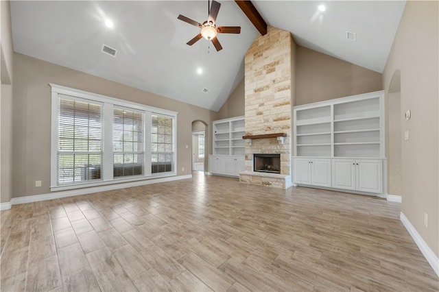 3520 Foxcroft Path, Bryan, TX 77808 - unfurnished living room with ceiling fan, arched walkways, beam ceiling, a stone fireplace, and baseboards