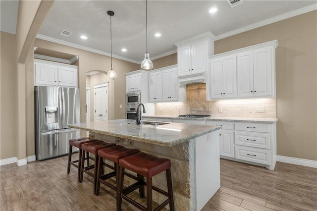 3520 Foxcroft Path, Bryan, TX 77808 - kitchen with stainless steel appliances, arched walkways, a sink, baseboards, and ornamental molding