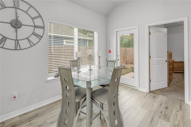 dining room with light hardwood / wood-style floors and lofted ceiling