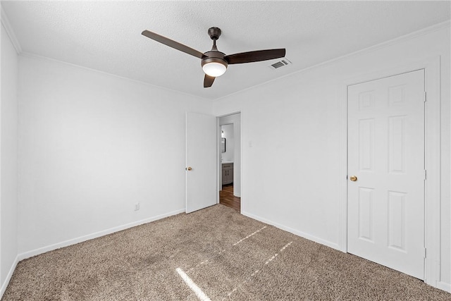 unfurnished bedroom with carpet, ceiling fan, ornamental molding, and a textured ceiling