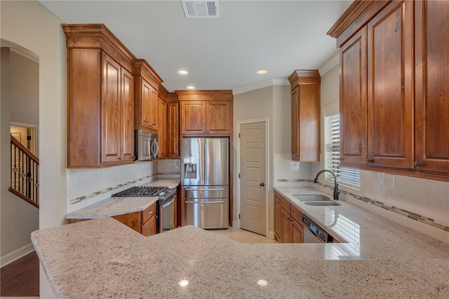 kitchen featuring crown molding, sink, light stone countertops, tasteful backsplash, and stainless steel appliances