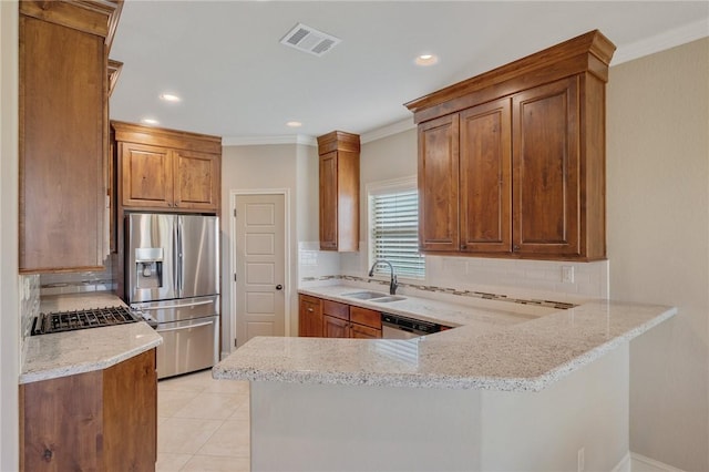 kitchen featuring stainless steel appliances, light stone counters, tasteful backsplash, and sink