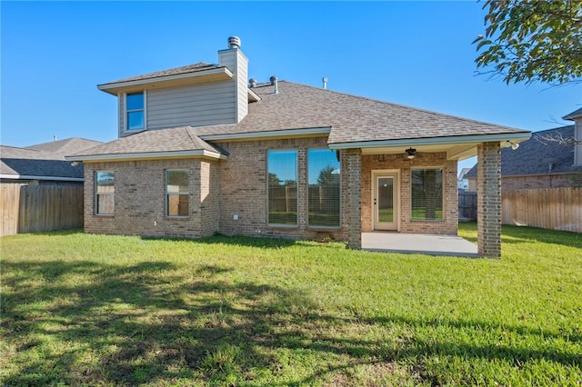 back of property with ceiling fan, a patio area, and a lawn