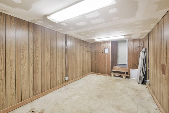 basement featuring wood walls